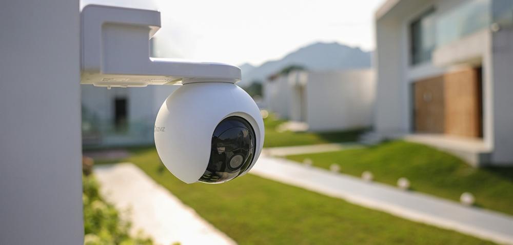 Weiße EZVIZ Überwachungskamera im Außenbereich eines modernen Wohnhauses zur Erhöhung der Sicherheit